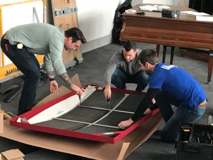 Wenger’s Matt Hildebrand, Product Manager, Acoustics, unpacks an acoustic wall treatment with The Build Up’s Anthony Carrino and John Colaneri